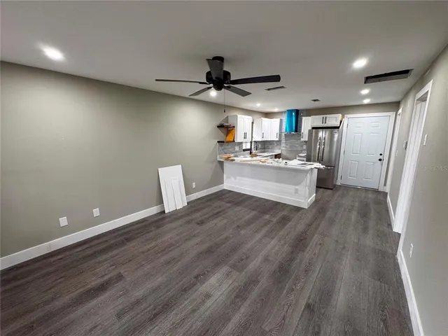 a view of a kitchen with a sink and dishwasher a refrigerator with wooden floor
