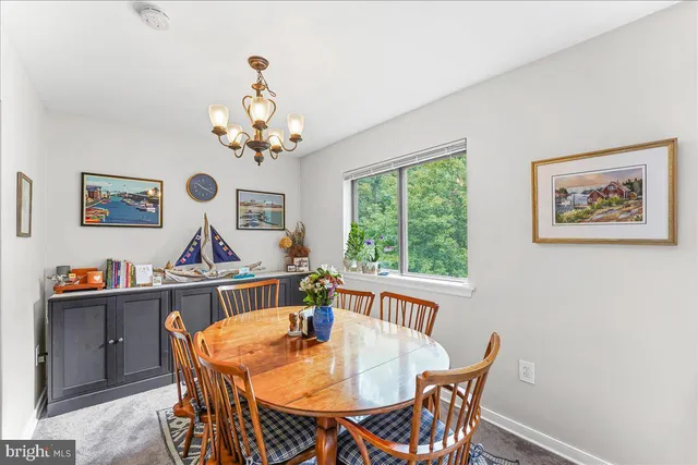 a view of a dining room with furniture a chandelier and a window