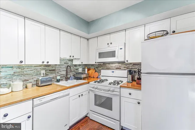 a kitchen with refrigerator a stove a sink and cabinets