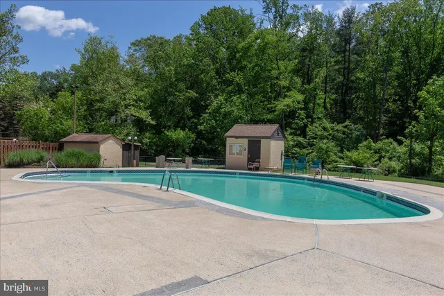 a view of a swimming pool and lounge chairs in the patio