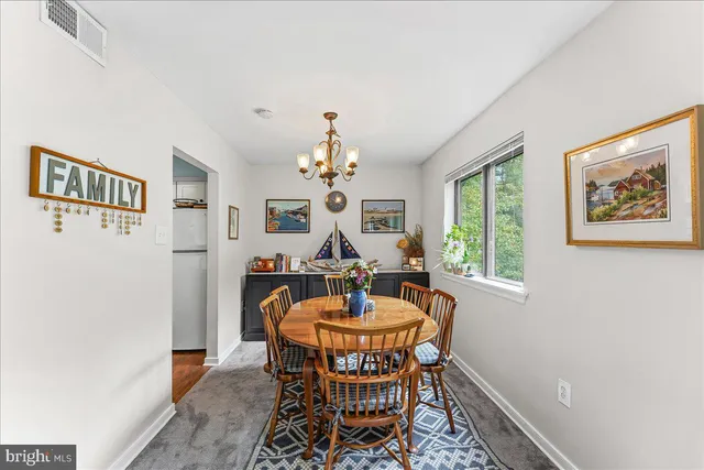 a dining room with furniture a chandelier and window