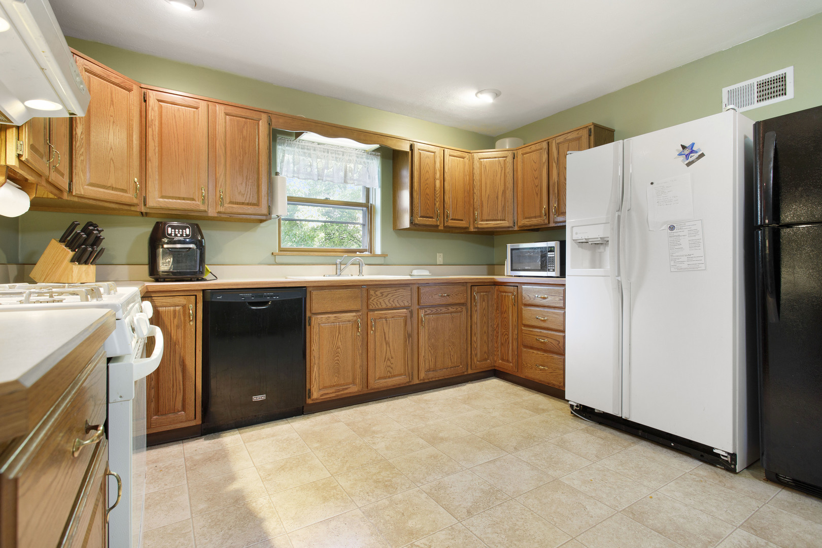 21517 Dunham Road Harvard, IL 60033 - Photo 2 of 36 a kitchen with a refrigerator a stove a sink dishwasher and cabinets