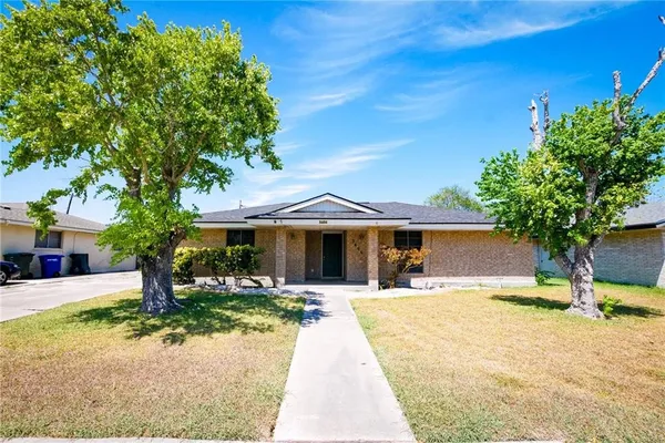 a view of a house with yard and palm tree