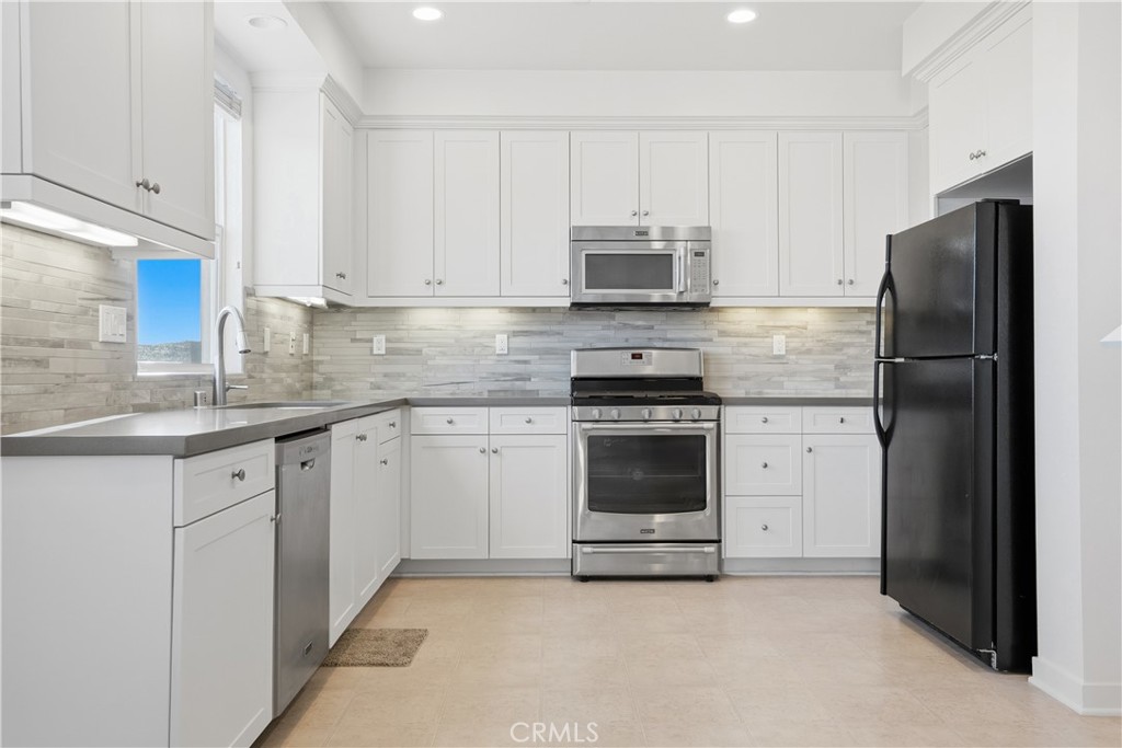 179 Patria Rancho Mission Viejo, CA 92694 - Photo 7 of 75 a kitchen with stainless steel appliances granite countertop white cabinets a refrigerator and a stove