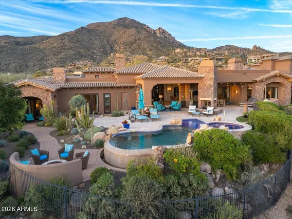 a view of a patio with couches table and chairs under an umbrella