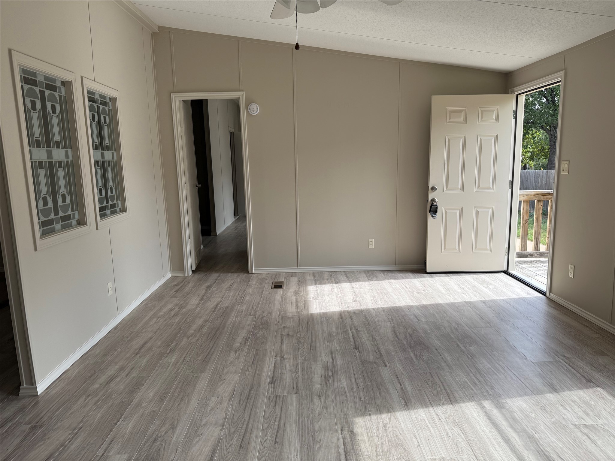 20701 Liveoak Lane Manor, TX 78653 - Photo 20 of 31 Empty room with a decorative wall, wood finished floors, and a ceiling fan
