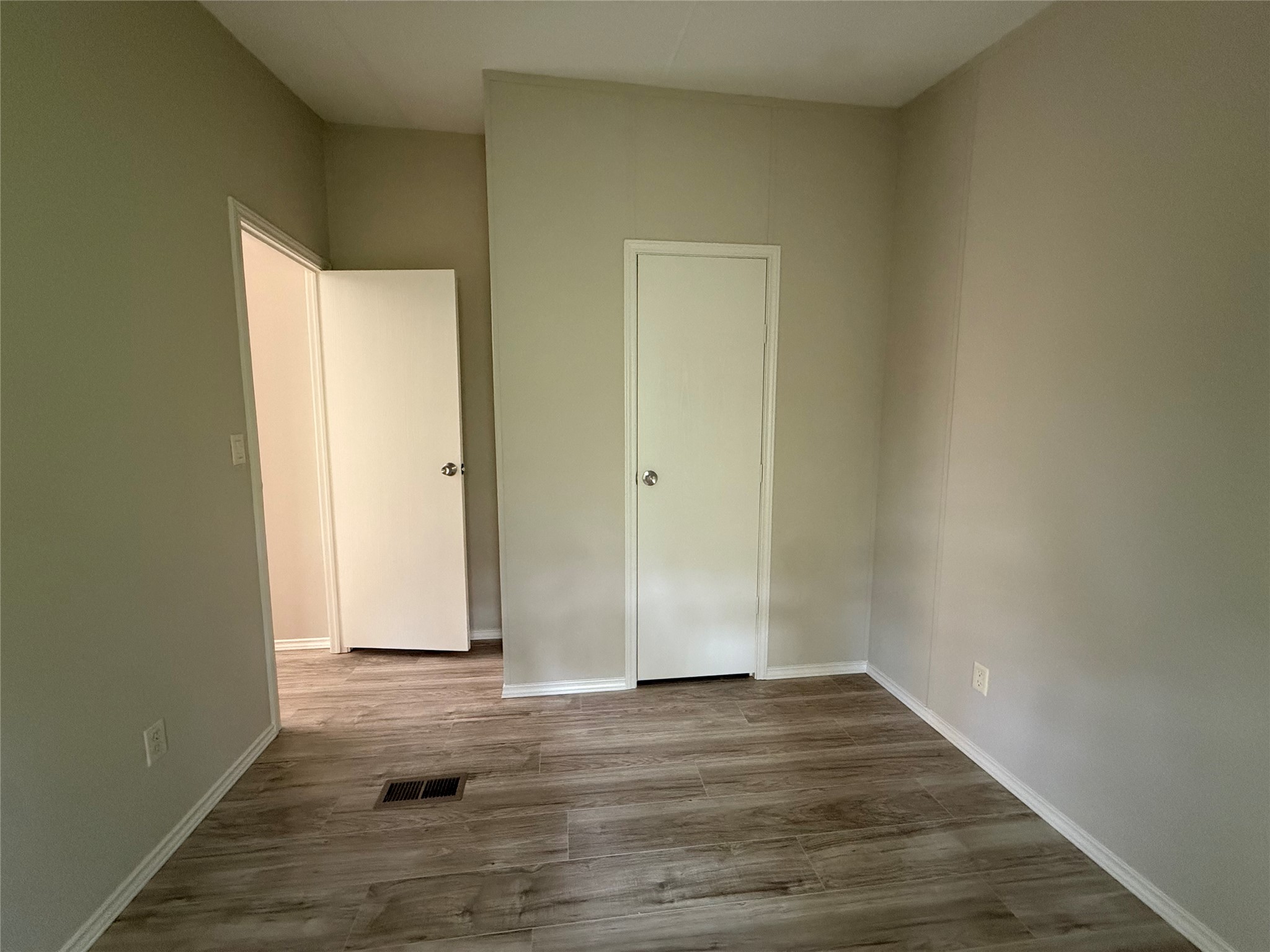 20701 Liveoak Lane Manor, TX 78653 - Photo 6 of 31 Unfurnished bedroom featuring dark wood-style flooring and baseboards