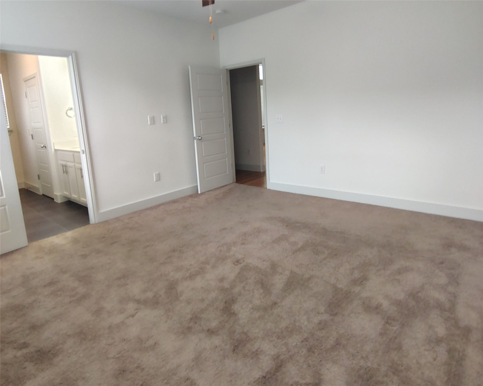 2214 Capulet Street Austin, TX 78741 - Photo 12 of 28 Unfurnished bedroom featuring a ceiling fan, ensuite bath, and dark carpet