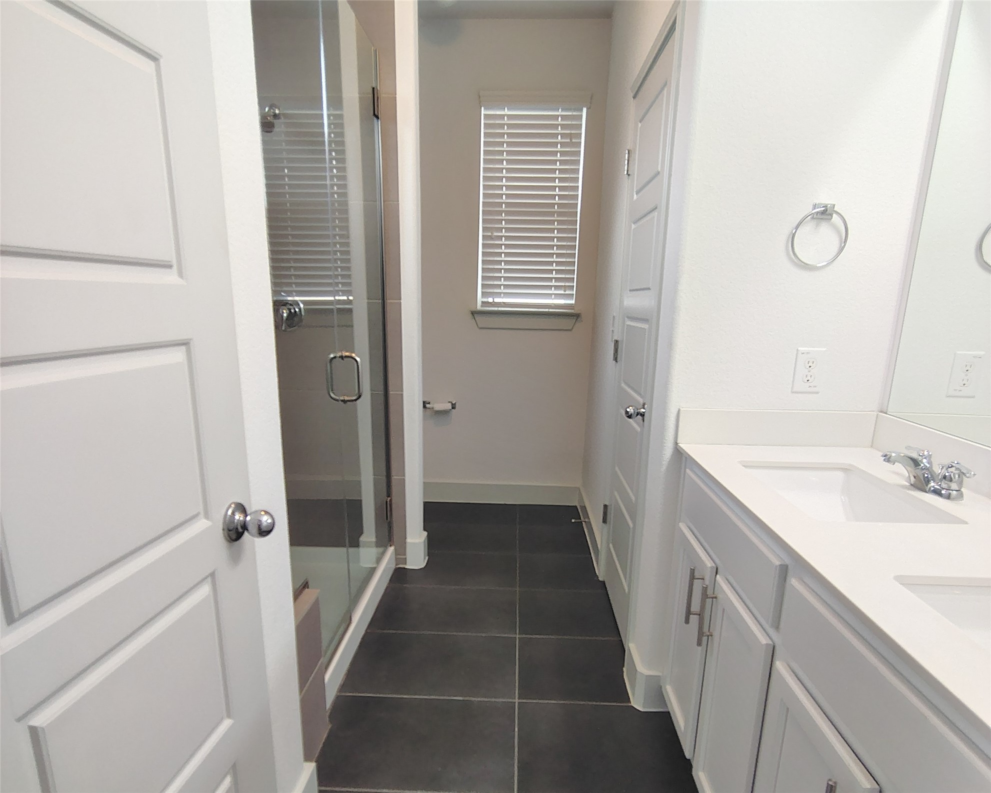 2214 Capulet Street Austin, TX 78741 - Photo 10 of 28 Bathroom featuring a shower stall, double vanity, and dark tile patterned flooring