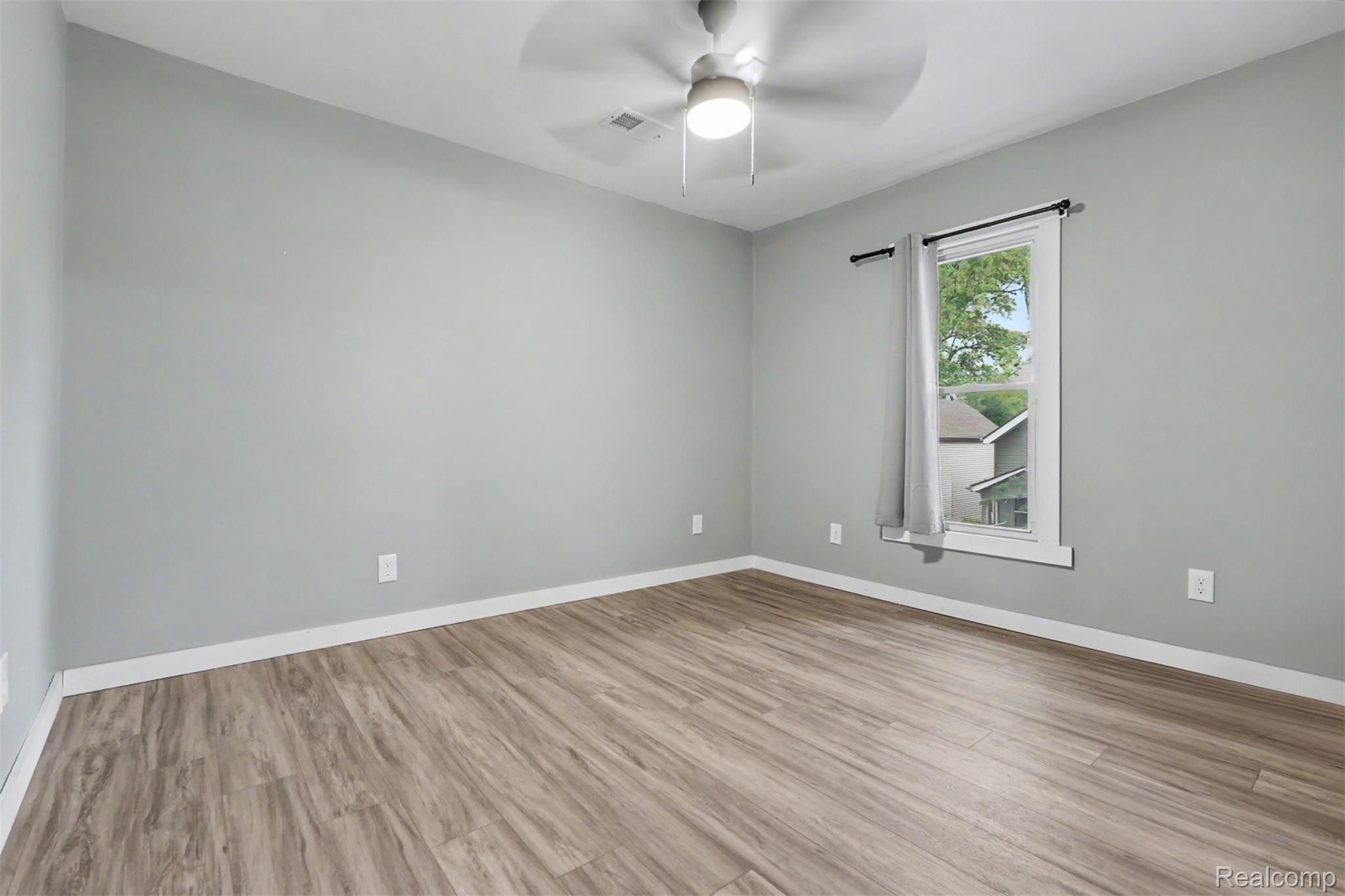 8397 Lane Street Detroit, MI 48209 - Photo 34 of 41 Light gray walls, wood-finish flooring, white trim, and a ceiling fan with integrated lighting