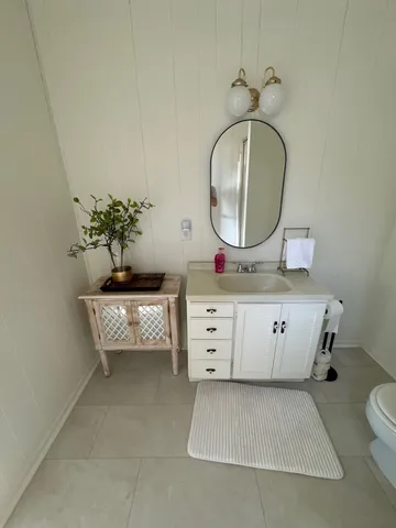 a room with painting on the wall and a mirror