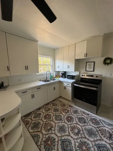 a kitchen with a stove sink and cabinets