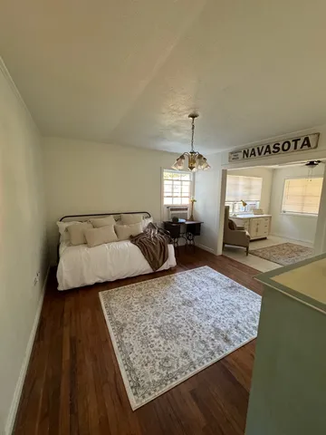 a bedroom with a large bed and a chandelier