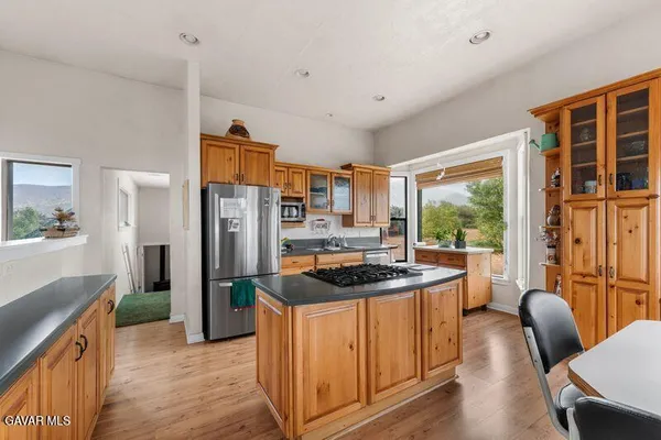 a kitchen with stainless steel appliances granite countertop a refrigerator a stove and a wooden cabinets