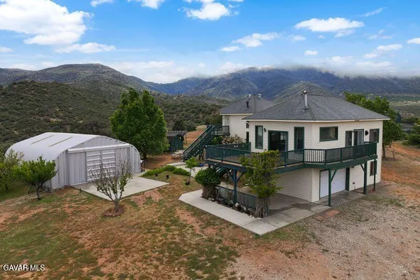 a view of a house with a yard and sitting area