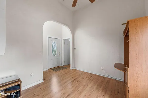 an empty room with wooden floor and mirror