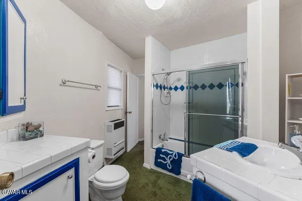 a bathroom with a sink toilet vanity and shower