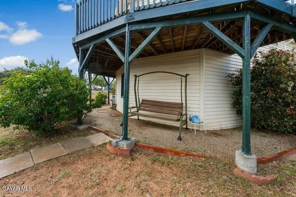 a view of a bedroom with a balcony and wooden fence