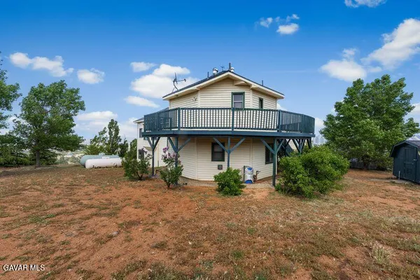 a view of a house with a yard and sitting area