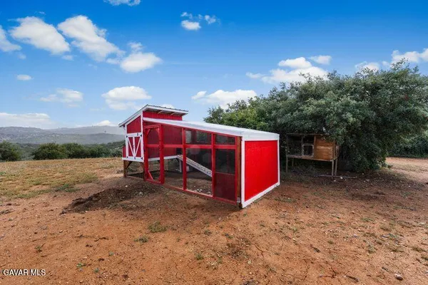 a backyard of a house with a garden and barbeque oven