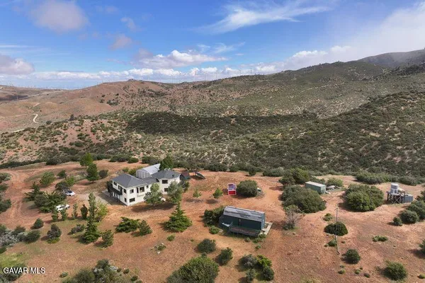 an aerial view of a house with a mountain