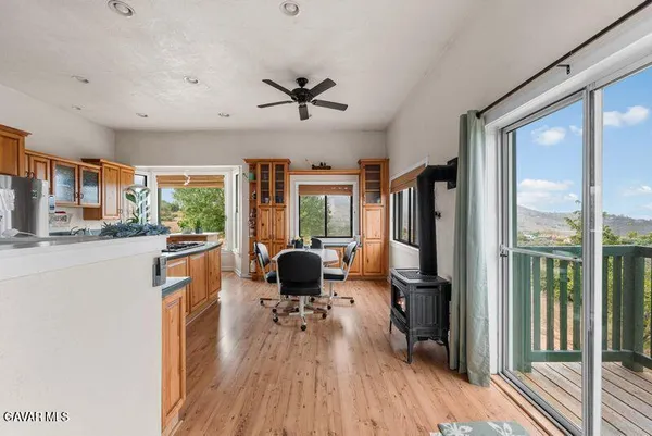 a living room with furniture a large window and wooden floor