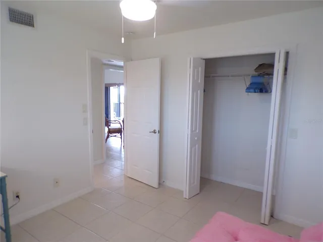 a view of a hallway with wooden floor and a bathroom