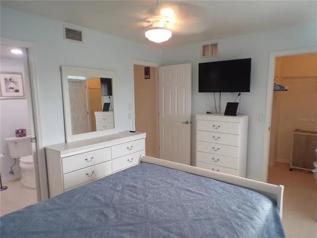 a room with a bed and a flat tv screen in it
