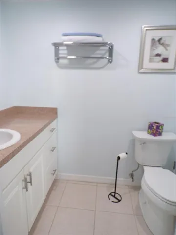 a bathroom with a granite countertop toilet and a sink