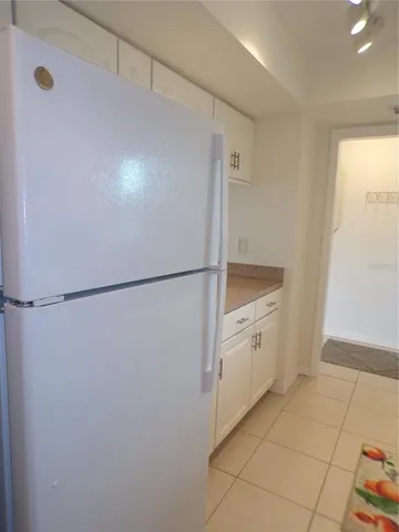 a kitchen with white cabinets and white appliances