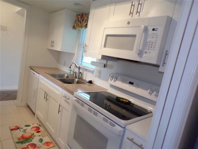 a kitchen with a sink a stove and cabinets