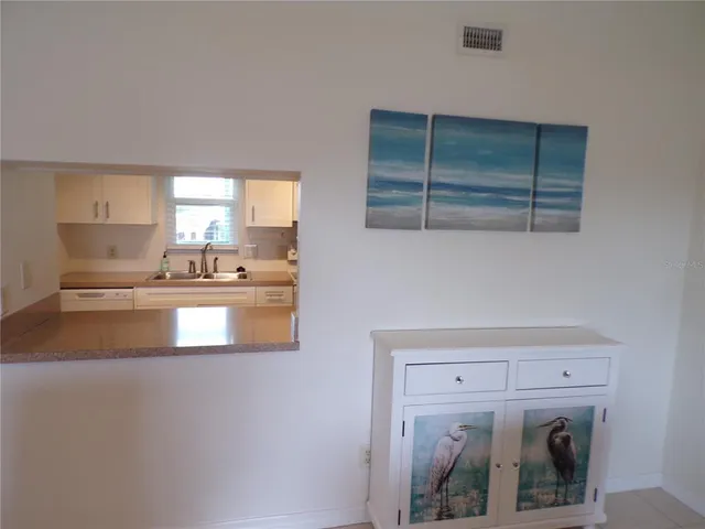 a kitchen with kitchen island a sink a stove and a refrigerator with cabinets