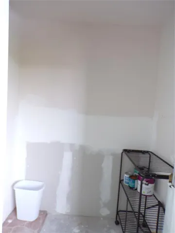 a bathroom with a toilet and a chair