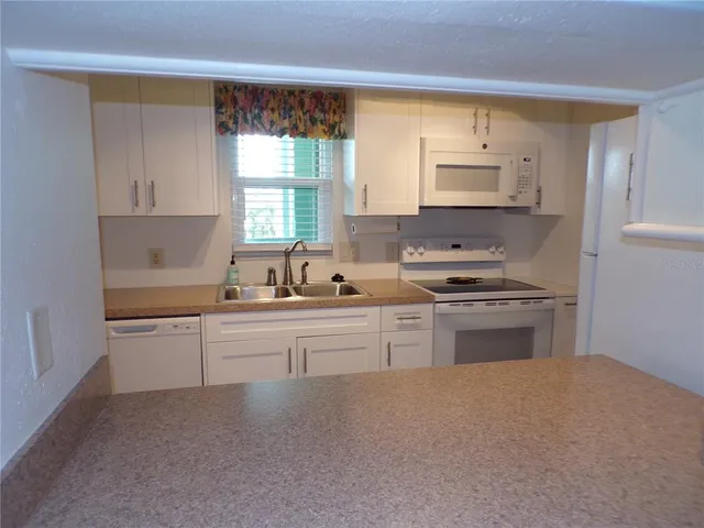 a kitchen with granite countertop a sink stainless steel appliances and cabinets