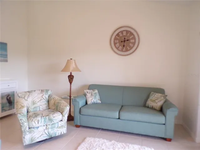 a living room with furniture a wall clock and a window