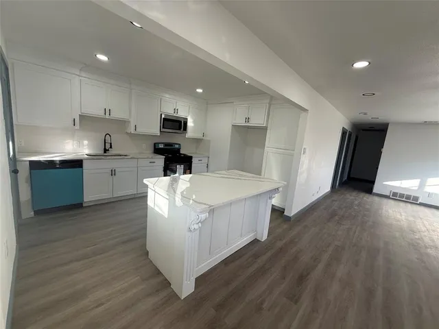 a kitchen with a sink a refrigerator and cabinets