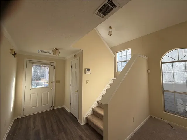 a view of a hallway with wooden floor and staircase