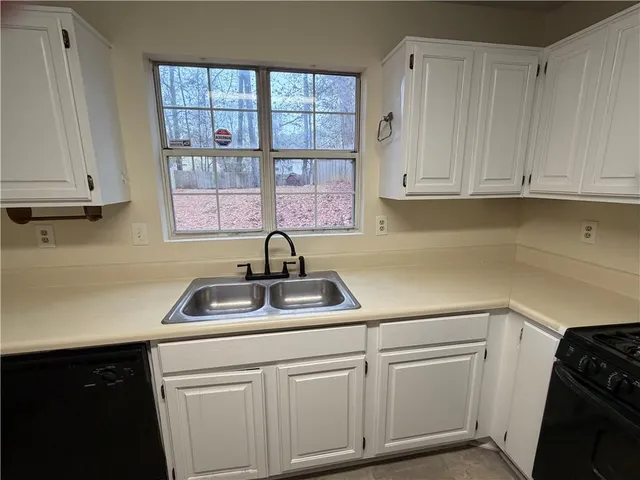 a kitchen with white cabinets and a sink