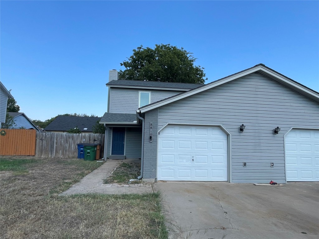 8810 Springmail Circle, Unit B Austin, TX 78729 - Photo 1 of 26 a front view of a house with a yard and garage