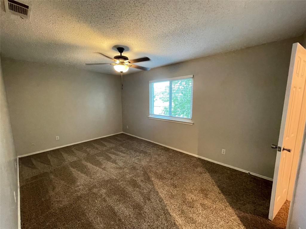 8810 Springmail Circle, Unit B Austin, TX 78729 - Photo 19 of 26 an empty room with windows and fan