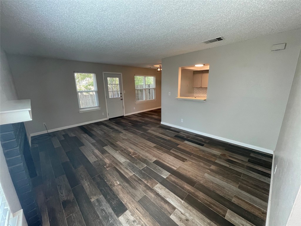 8810 Springmail Circle, Unit B Austin, TX 78729 - Photo 3 of 26 a view of an empty room with wooden floor and a window