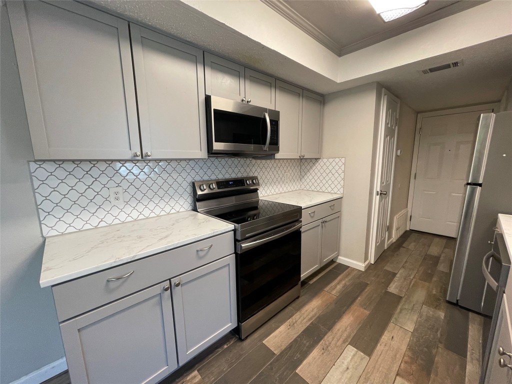 8810 Springmail Circle, Unit B Austin, TX 78729 - Photo 8 of 26 a kitchen with a sink stove and microwave