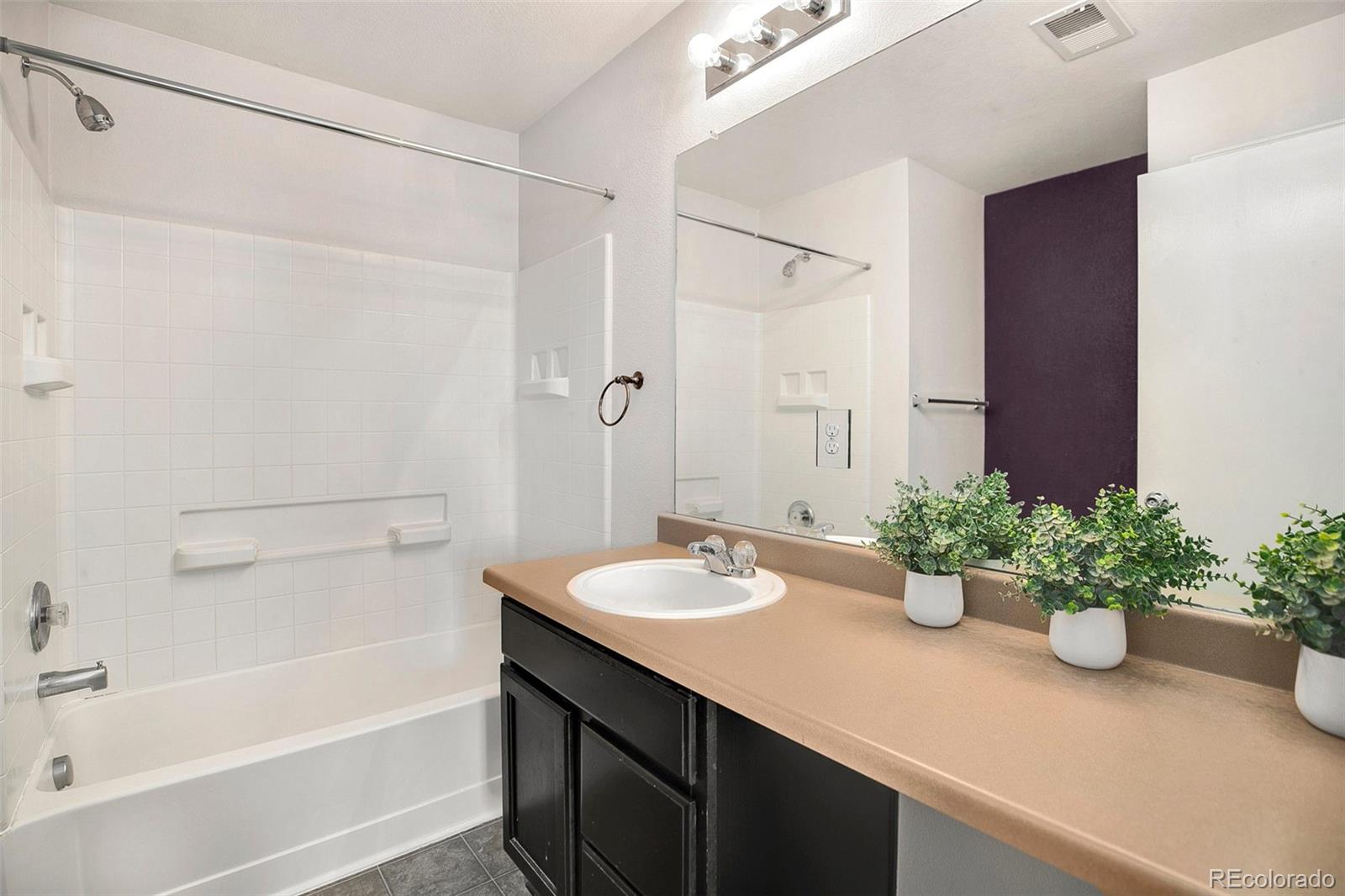 2011 Uinta Street Denver, CO 80238 - Photo 17 of 28 a bathroom with a granite countertop sink a mirror and a shower