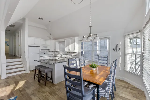 a living room with stainless steel appliances granite countertop furniture a fireplace a rug and a window