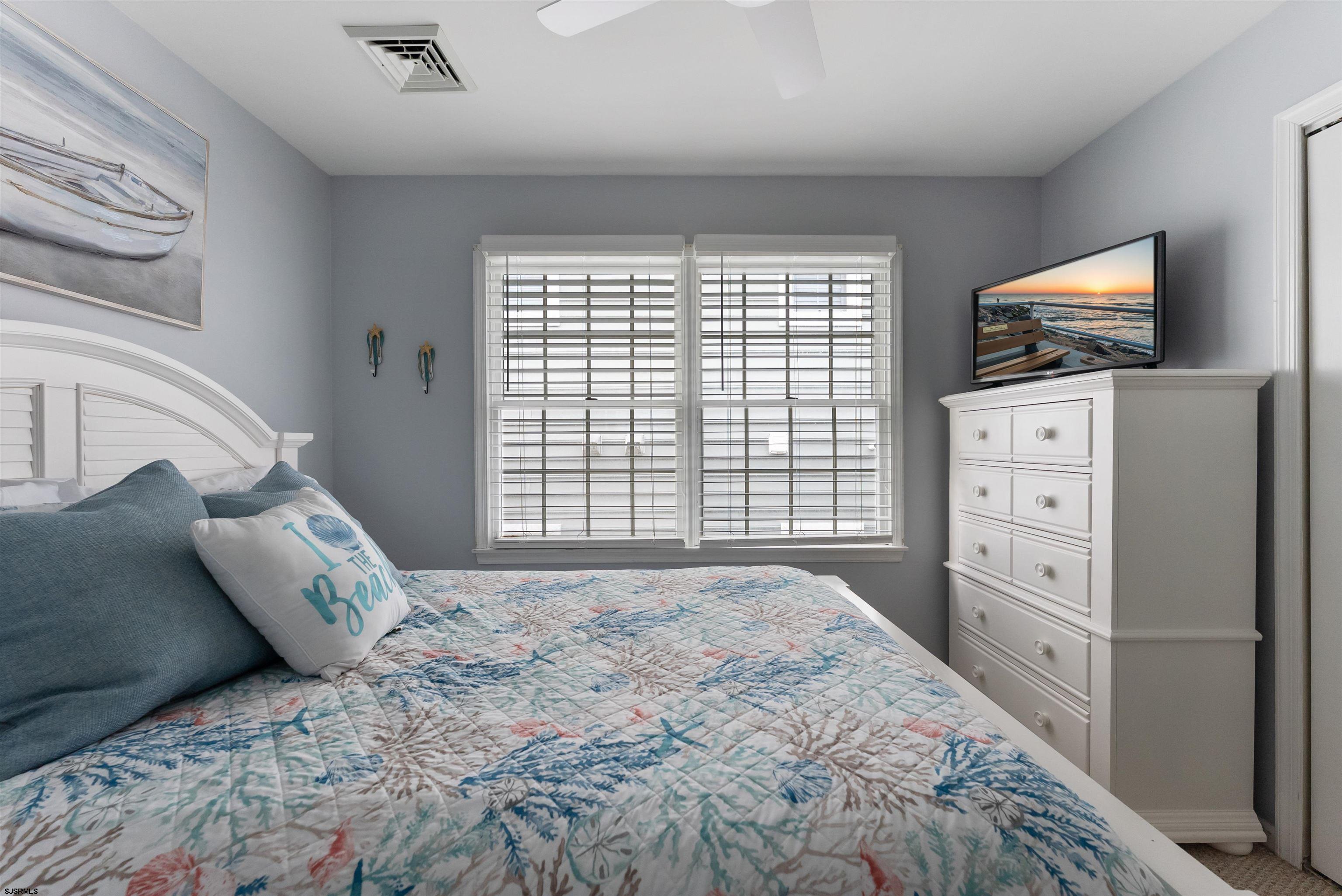 4930 Asbury Avenue, Unit 2 Ocean City, NJ 08226 - Photo 17 of 25 a bedroom with a bed and a flat screen tv