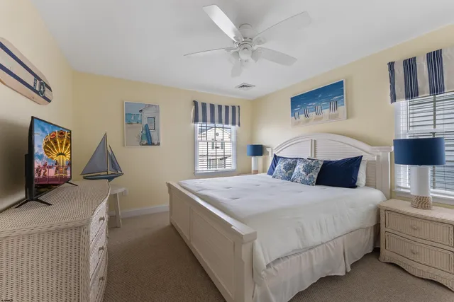 a bedroom with a large bed and a flat tv screen on dresser