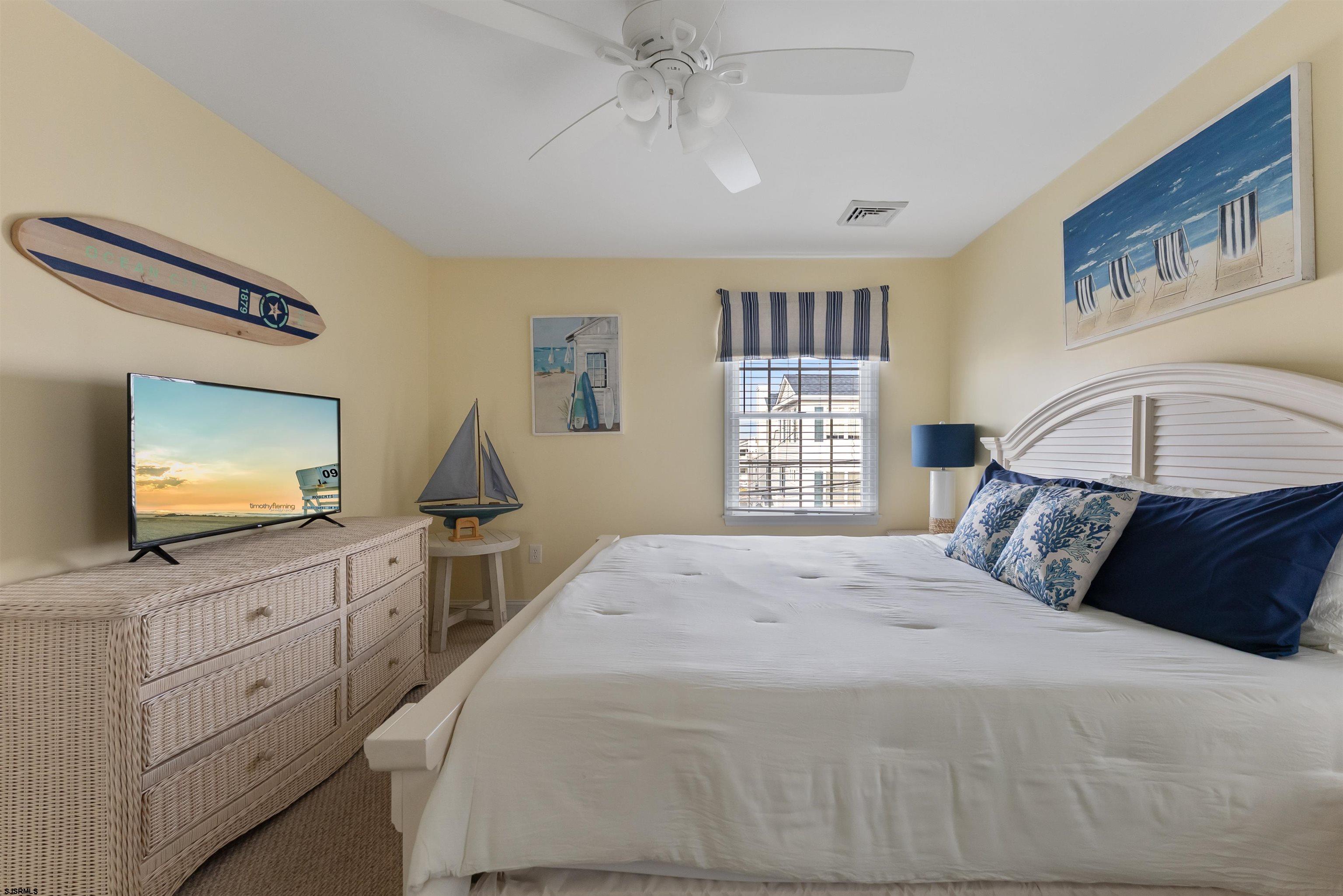 4930 Asbury Avenue, Unit 2 Ocean City, NJ 08226 - Photo 21 of 25 a bedroom with a large bed and a flat tv screen on dresser