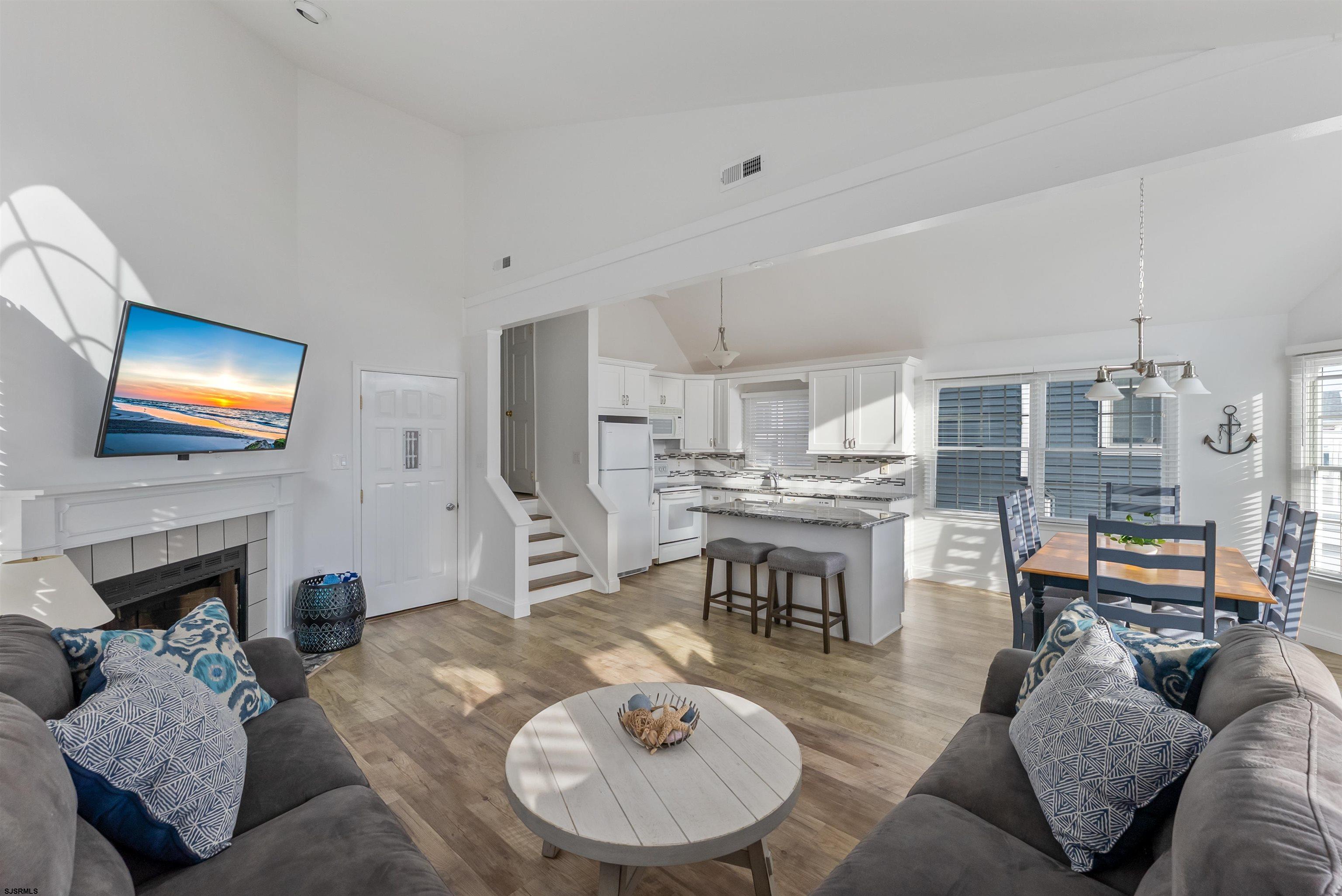4930 Asbury Avenue, Unit 2 Ocean City, NJ 08226 - Photo 4 of 25 a living room with furniture a fireplace and a flat screen tv