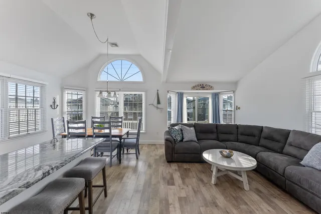 a kitchen with granite countertop a table chairs stove and wooden cabinets