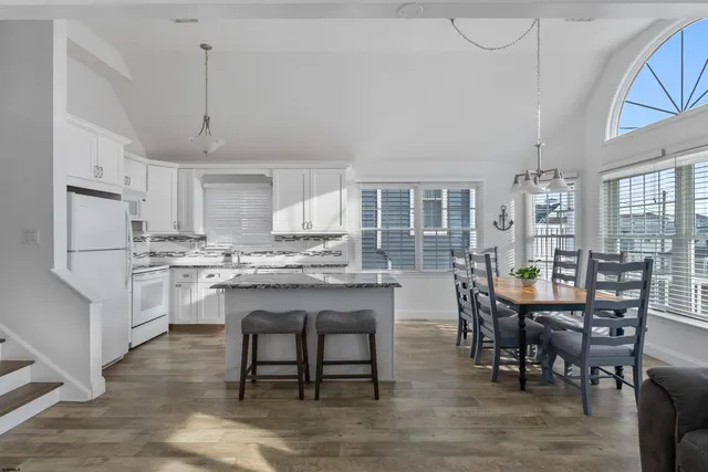 a kitchen with stainless steel appliances granite countertop a sink and a refrigerator